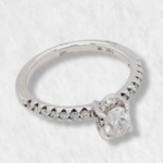 Anillo Compromiso c/ Diamante Oval Central & Aro c/ Diamantes Pave - Oro Blanco 14Kts